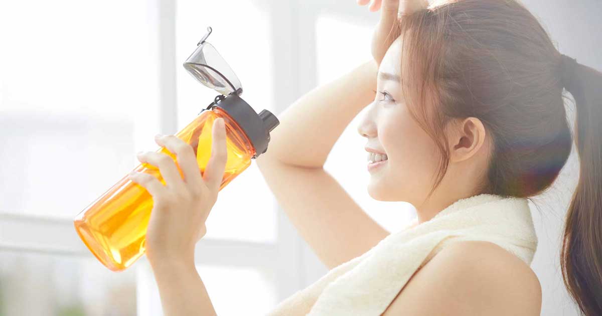 トレーニング後にプロテインと水を持つ女性